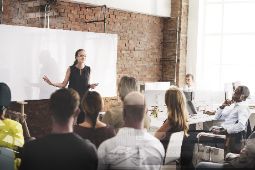 Dozentin steht vor weißer Tafel