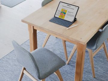 Tisch mit einem Tablet und einem Stuhl davor