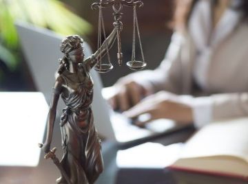 Justitia auf einem Schreibtisch