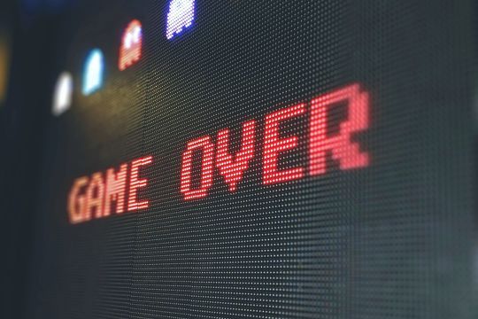 Auf einem Bildschirm steht "Game Over". Daneben sind Pacman-Geister