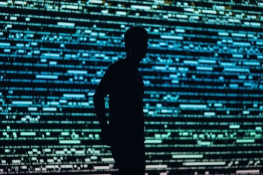 Silhouette einer Person vor grün-blauem Hintergrund
