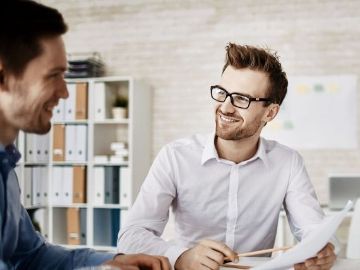 Zwei Menschen am Tisch mit Unterlagen